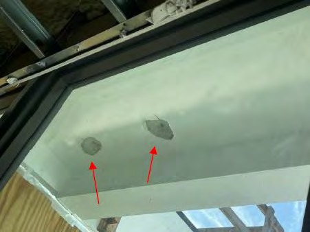 Holes drilled through balcony slab to drain ponding water — structural compromise